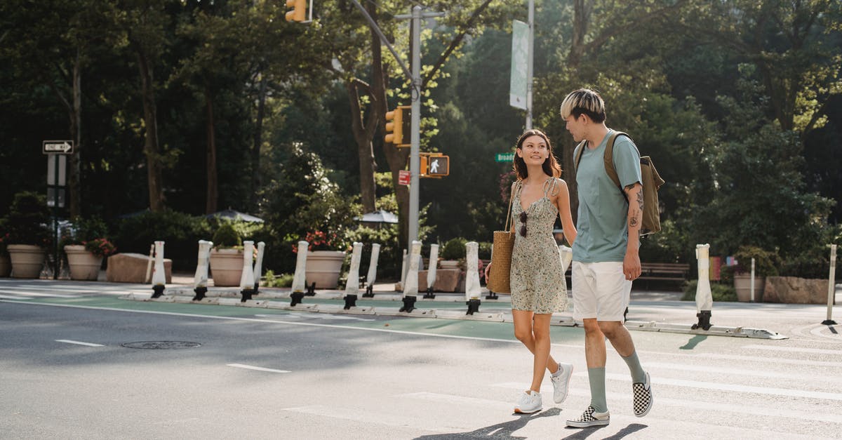 Cabin bag total linear length is 125 [closed] - Full body of happy young girlfriend carrying bag while walking on asphalt crosswalk with boyfriend