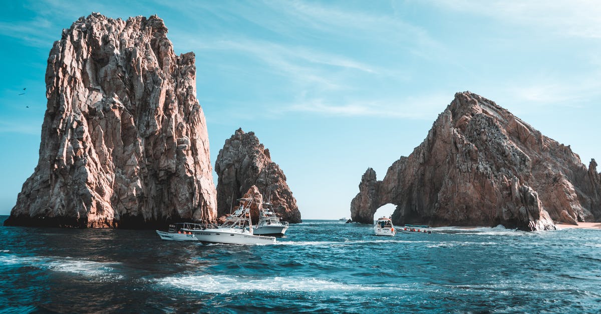 Cabo San Lucas Water Taxi - Photo of Boats on Ocean Near Rock Formations