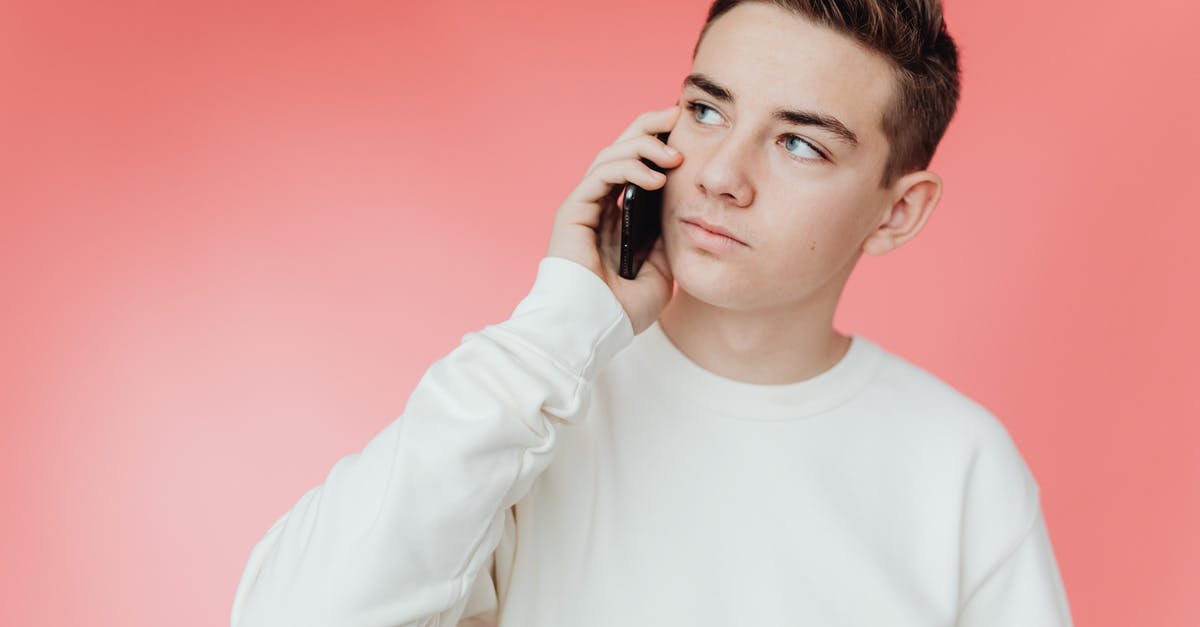 Calling within Europe - Man in White Crew Neck Long Sleeve Shirt Holding Black Smartphone