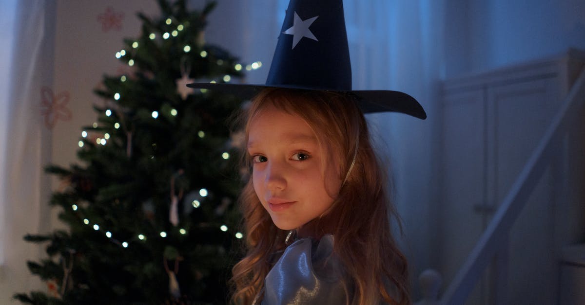 Cambodian visa extension for children - Girl in Black Cowboy Hat Standing Beside Green Christmas Tree