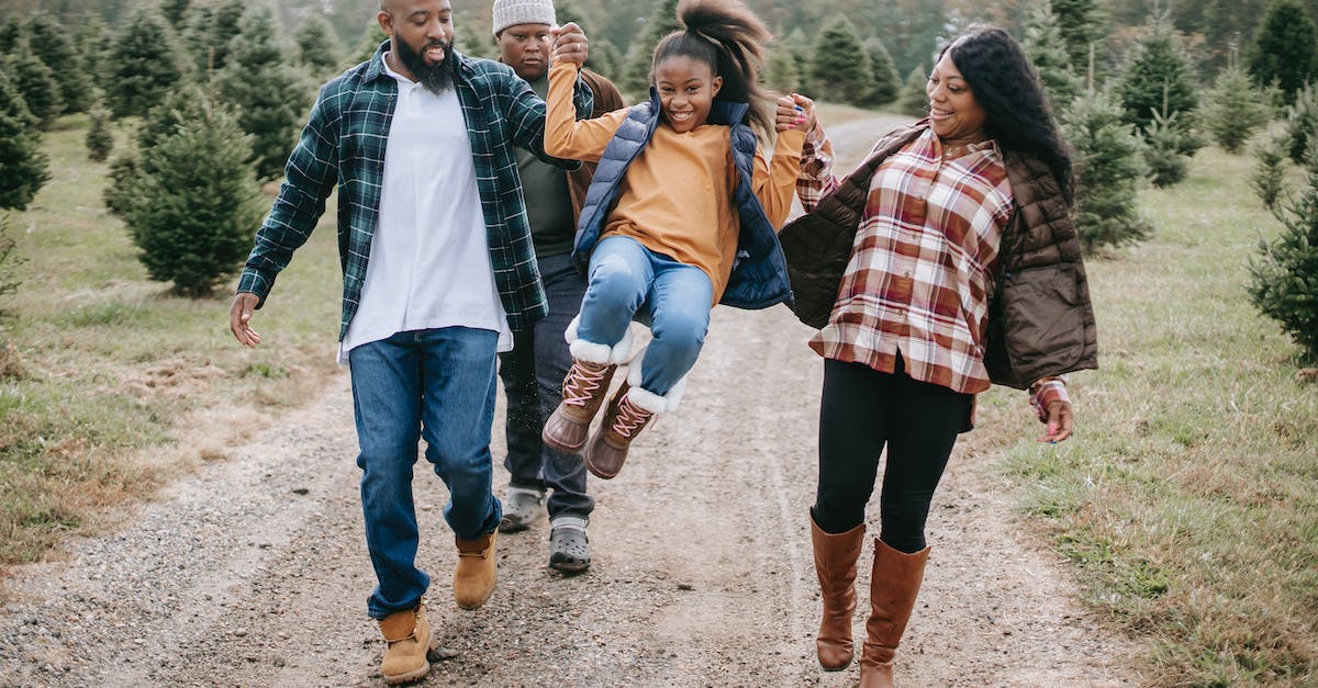 Camping around Toronto, Ontario for the new year weekend - Ethnic parents raising cheerful girl on tree farm roadway