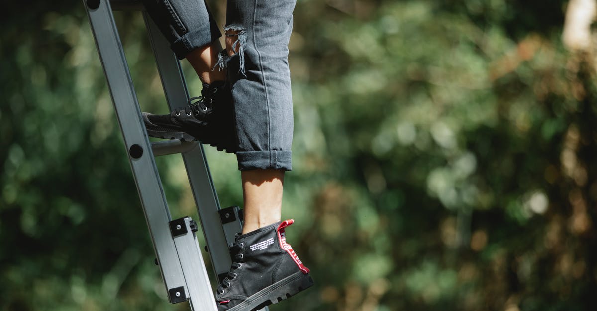 Camping safety in the Everglades in May - Faceless camper climbing ladder in forest