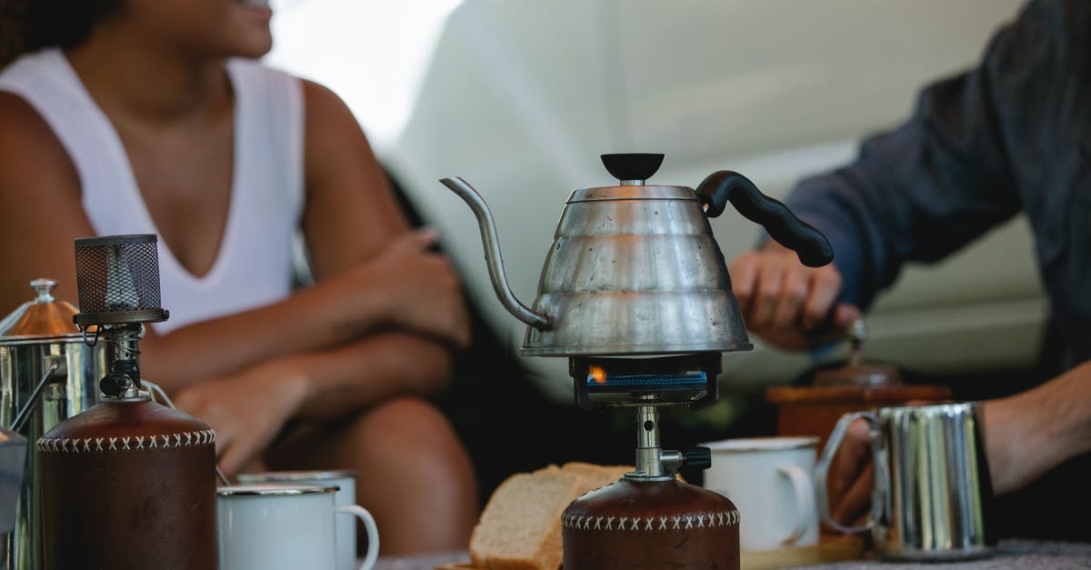 Camping stove on a plane? - Crop friends preparing coffee and boiling kettle on gas stove