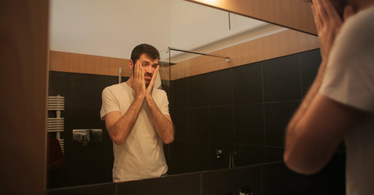 Can't check-in to a hotel because I am 18 - Tired man looking in mirror in bathroom