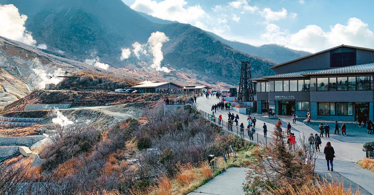 Can a foreign national tourist "open carry" a firearm in Yellowstone National Park? - Amazing landscape of national park with volcanic mountainous terrain with fume mist crowded with tourists and located in Hakone Japan