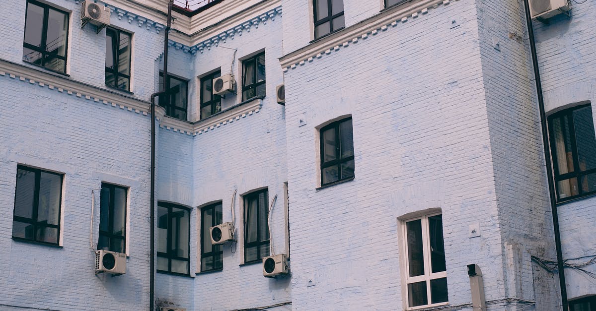 Can air conditioning units be rented in France? - Old house exterior with air conditioning units on walls