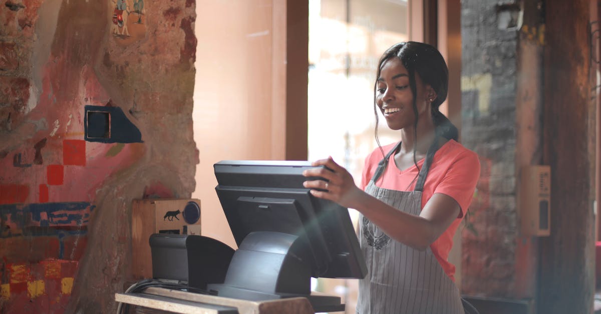 Can aircrew order me not to stand in the aisle? - Cheerful American African waitress in apron working on counter monitor while registering order at cozy cafe