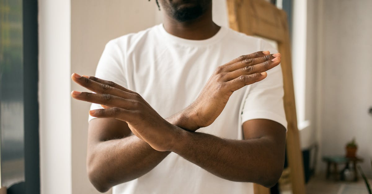 Can Airline Legally Refuse Boarding for NO Reason? - Crop unrecognizable bearded African American male in white t shirt demonstrating no gesture with hands while standing in light room