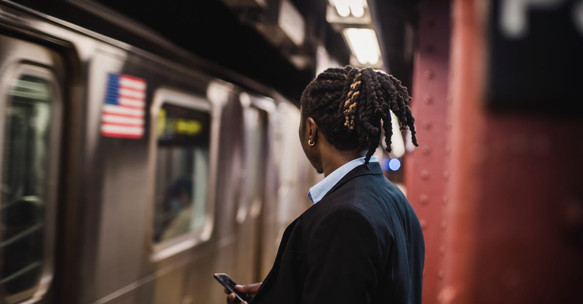 Can an American get a UK Transit Visa on Arrival? - Man in suit looking at arriving train on subway