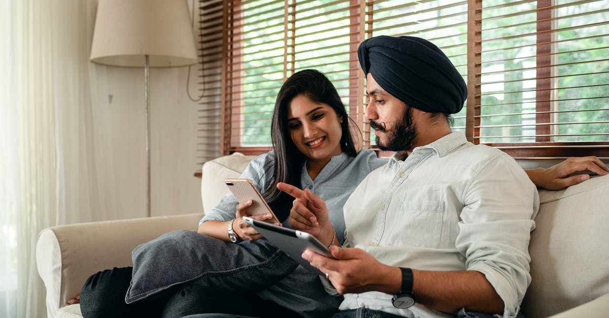 Can an Indian Tourist eVisa be used for Business [closed] - Young smiling Indian woman using smartphone and showing photo to husband working on tablet