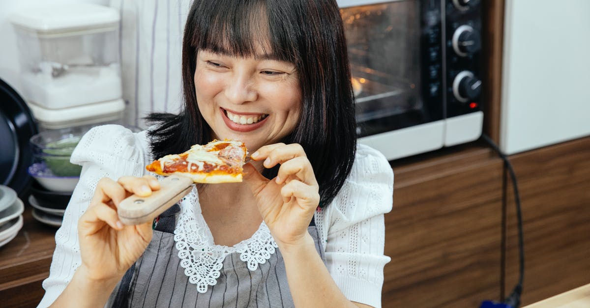 Can an Iranian with Italian residence enter Bulgaria visa free? [duplicate] - Happy Asian woman enjoying eating slice of cheesy pizza sitting at table in kitchen