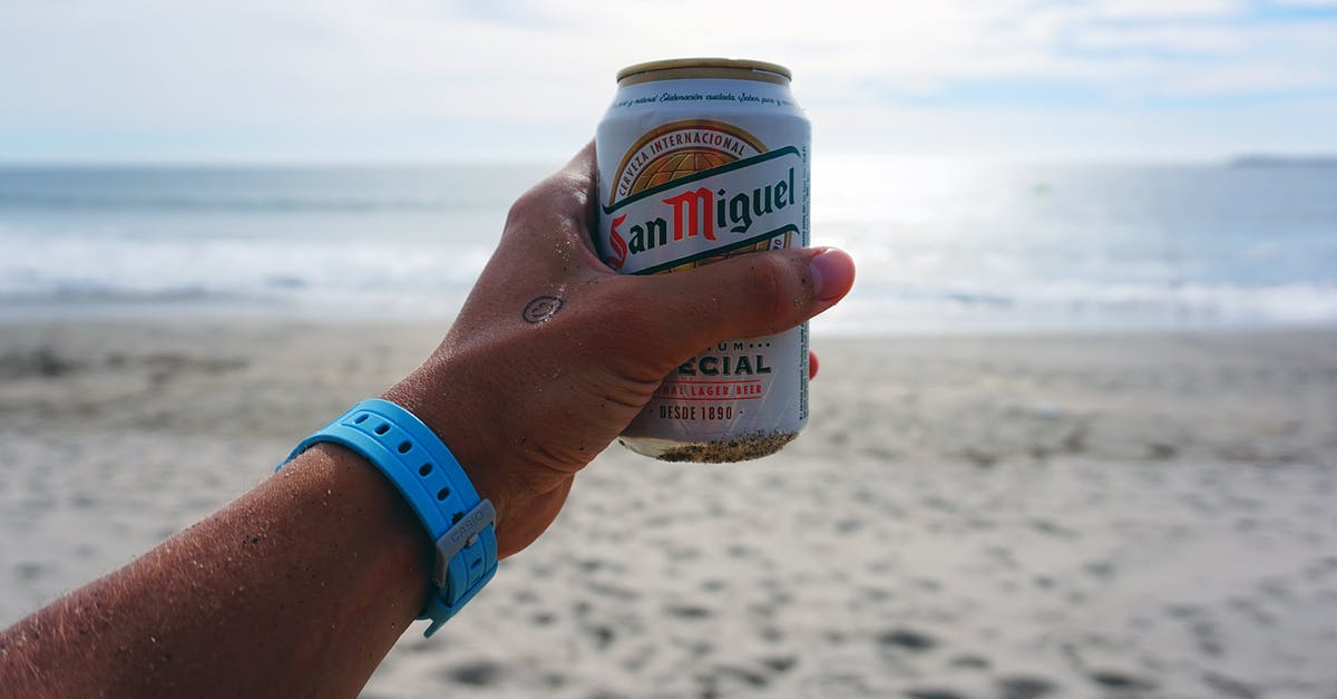 Can anyone identify this beach? - Person Holding San Miguel Beer Tin Can