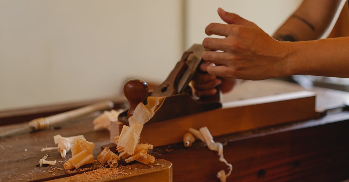 Can board a plane to Cameroon without a Cameroonian visa? - Crop joiner shaping hardwood plank with jack plane working at table in modern workshop