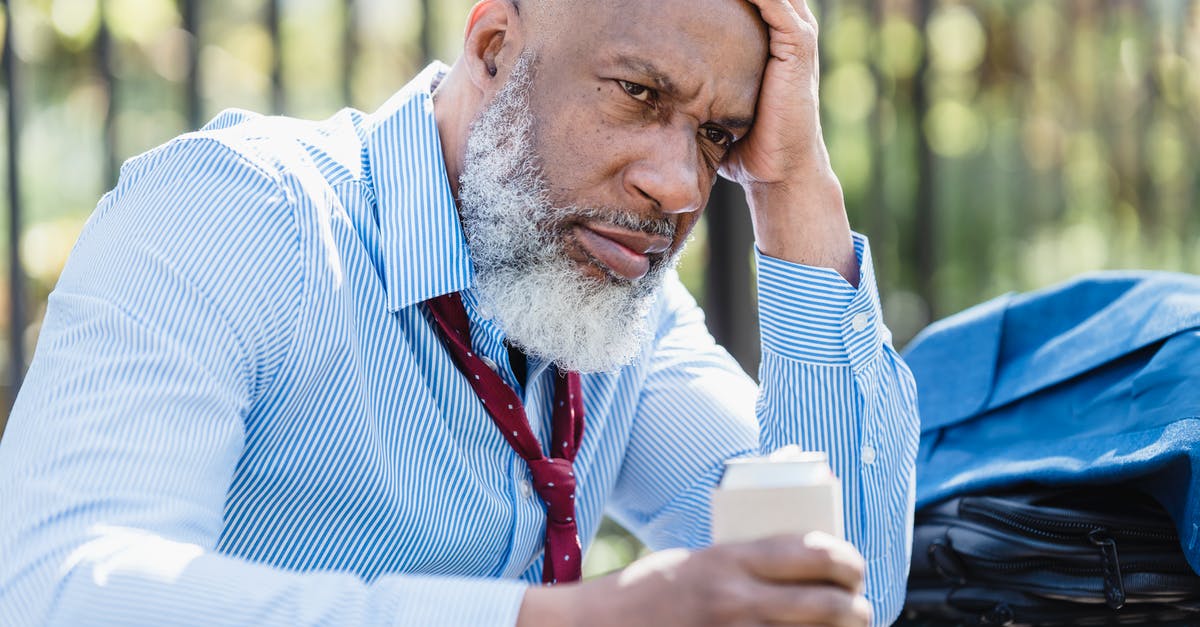 Can departing earlier than scheduled cause problems with UK Immigration? - Sad black businessman with alcohol drink on street