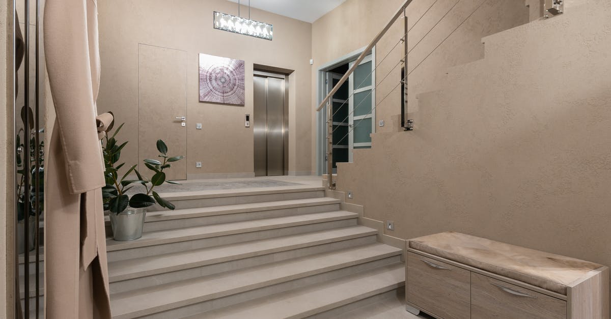 Can EU nationals enter and exit Albania with EU ID card? - Spacious hallway of contemporary apartment with beige walls and wide stairway under glowing lamps