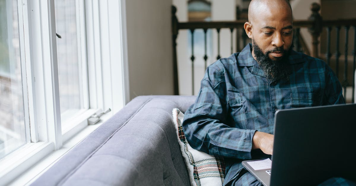 Can I add checked bags after online check-in (American) - Serious black man using laptop at home