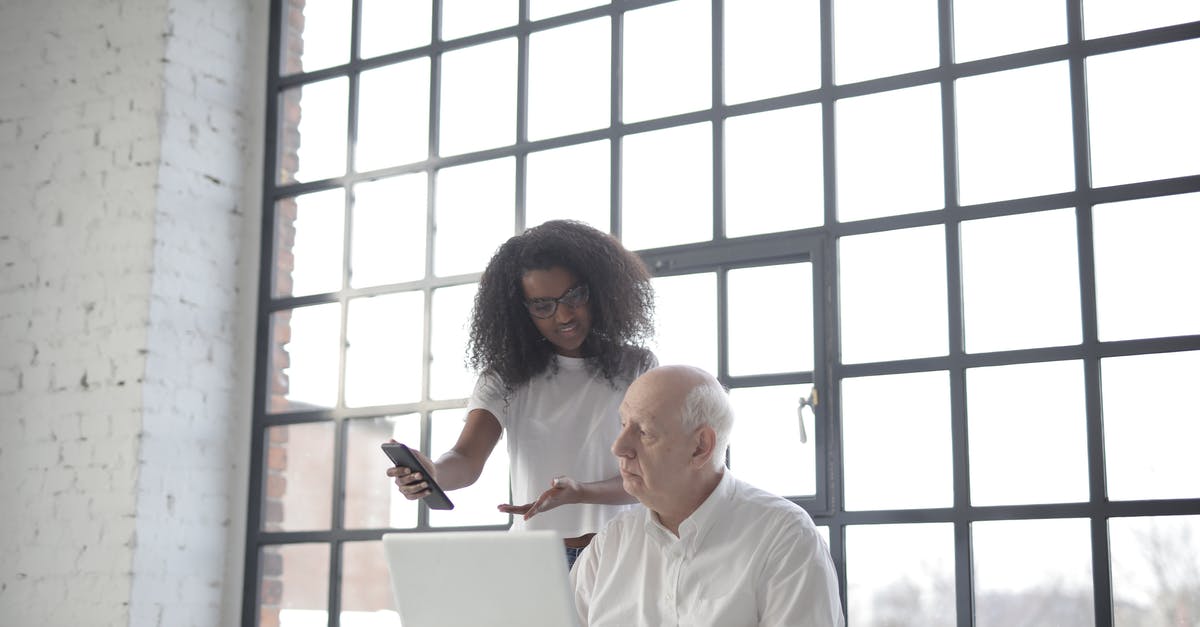 Can I ask to watch a TSA officer put on gloves? - Multiracial businesspeople of different ages using gadgets while working together in creative workplace