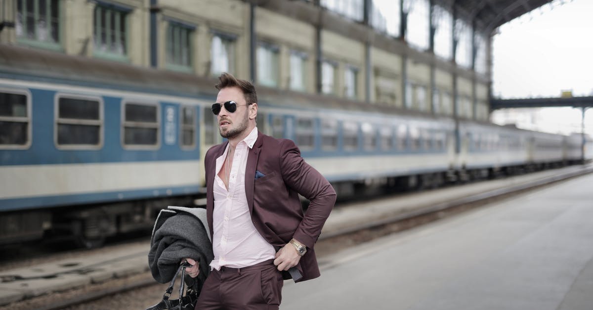 Can I bag wrap my suitcase at Leeds railway station? - Confident trendy male traveler in sunglasses standing on platform on railway station