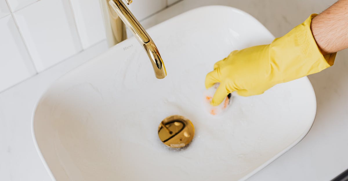 Can I bring duty free liquids through LIM-CDG-LHR? - Person in glove using sponge with detergent for cleaning sink