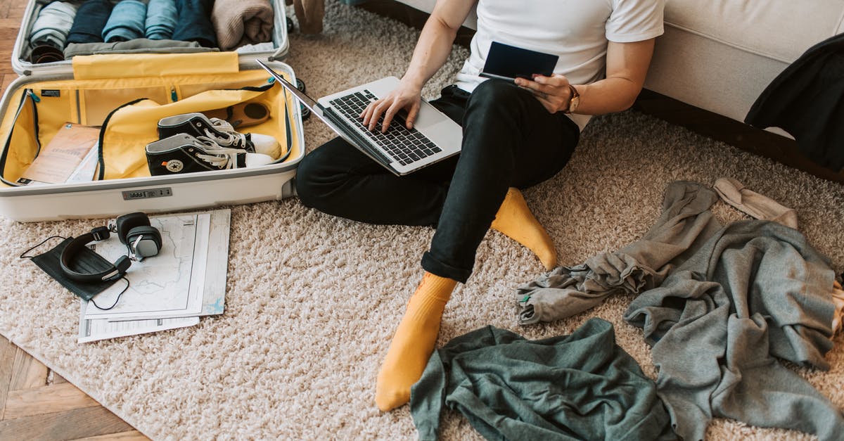 Can I bring DVDs and personal items in checked luggage - A Man Using His Laptop in a Messy Living Room