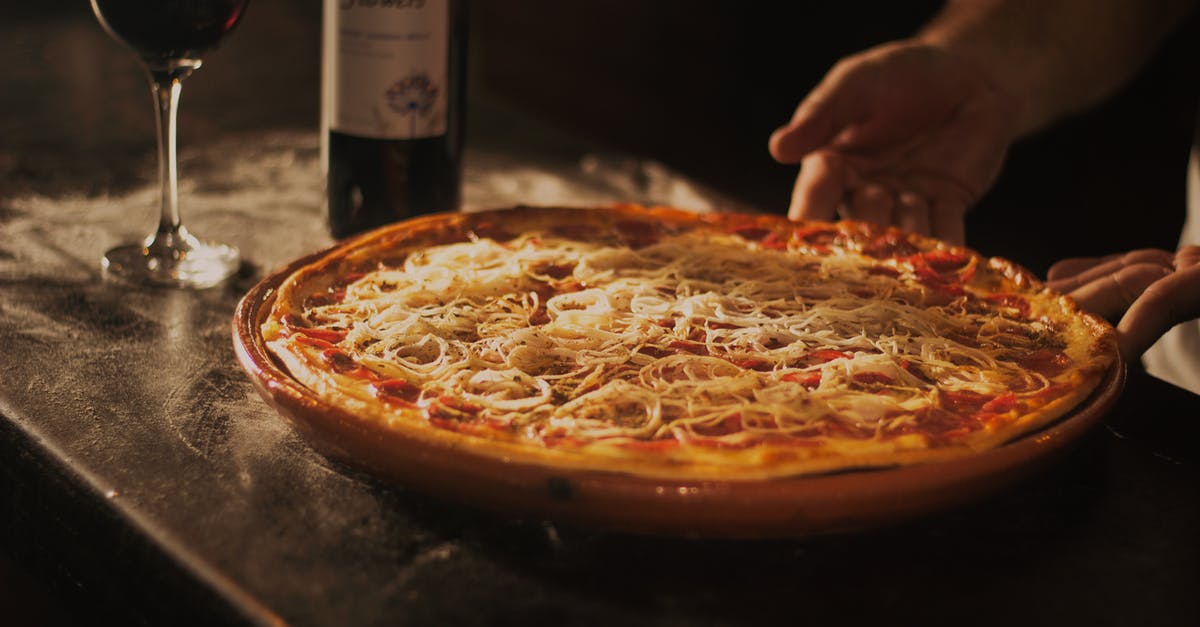 Can I bring meat pies in my checked-in bags? - Person Holding Pepperoni Pizza on Tray