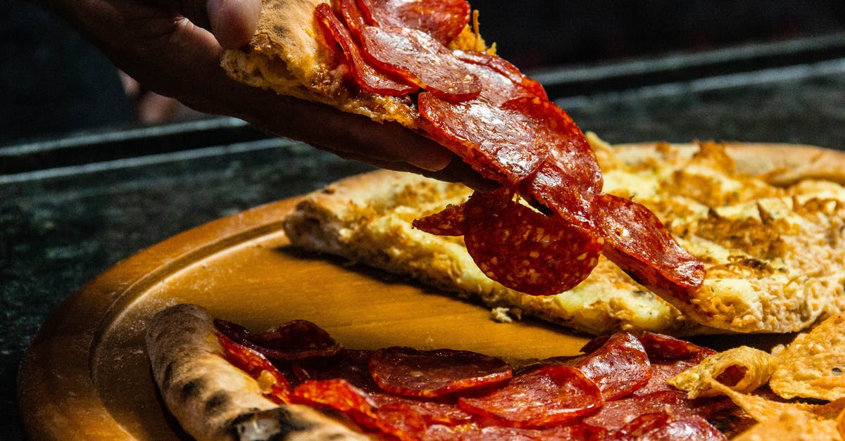 Can I bring meat pies in my checked-in bags? - Photo Of Person Holding Sliced Pizza