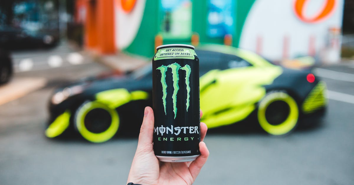 Can I bring other people's bodily liquids into the U.S.? - Unrecognizable person holding can of power drink while standing on parking lot near sport car