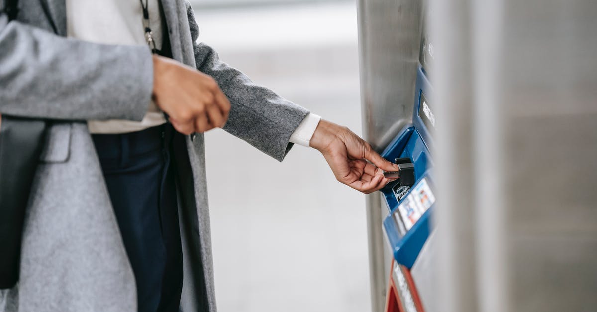 Can I buy a Barcelona Hola Card at a machine in the airport? - Faceless woman buying metro ticket via electronic machine