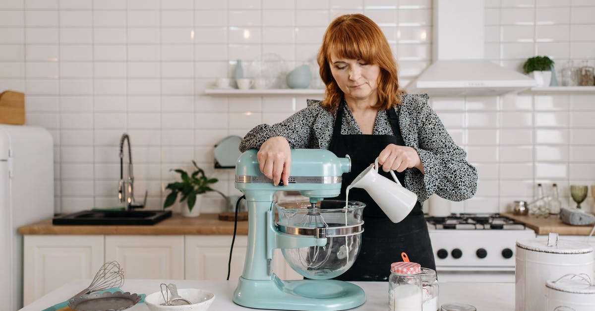 Can I buy pressure cookers and mixer grinders in Poland? - Woman in Black and White Long Sleeve Shirt Pouring Water on Clear Glass Pitcher