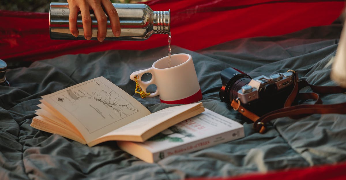 Can I camp on a campsite under 18 in Italy? - Crop faceless woman pouring tea from thermos during picnic