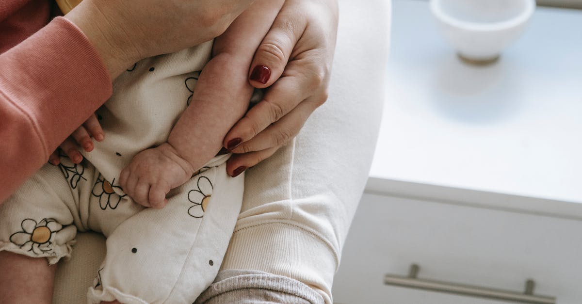 Can I carry a chef's torch in hand luggage? - Crop mother with baby in hands