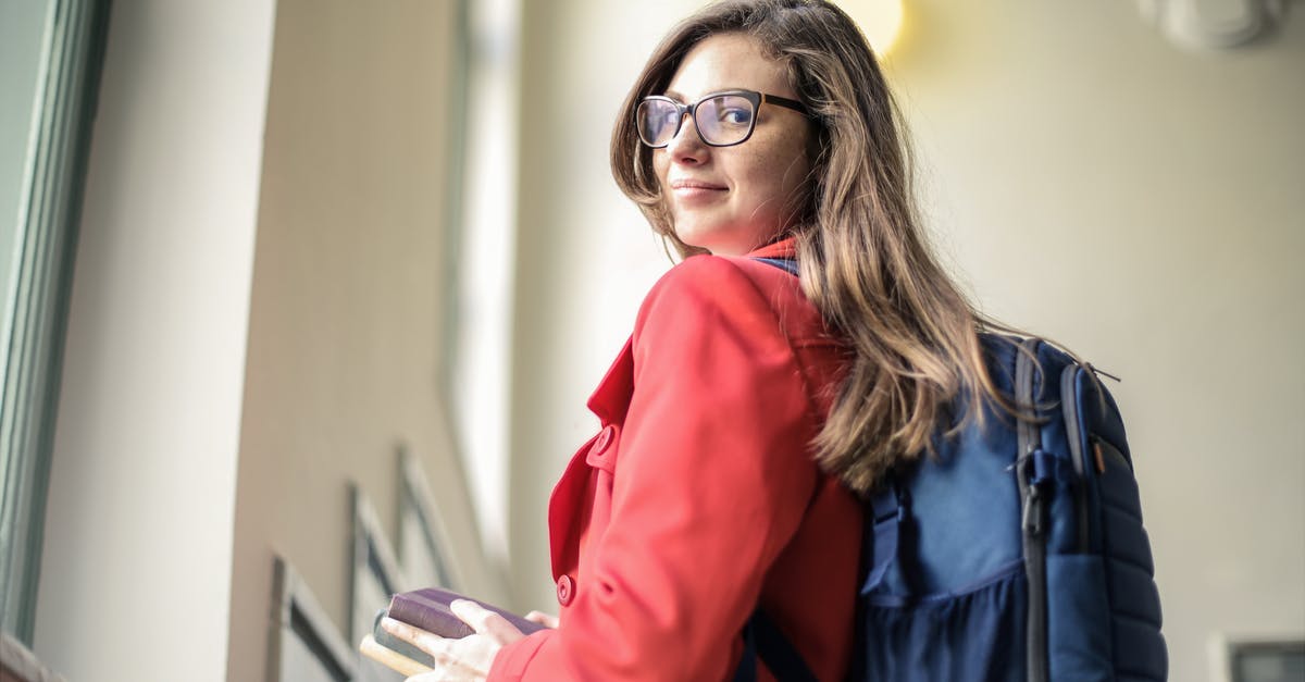 Can I carry hair oil and shampoo in my hand baggage? - Woman in Red Jacket Wearing Black Framed Eyeglasses