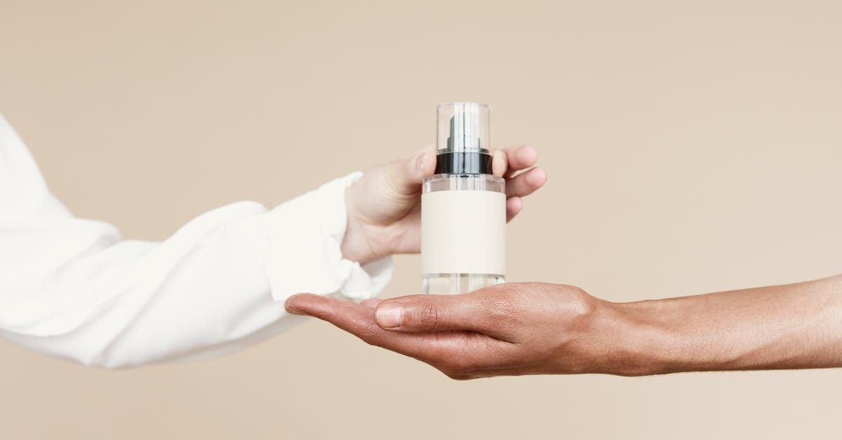 Can I carry hair oil and shampoo in my hand baggage? - Person Holding White and Silver Bottle