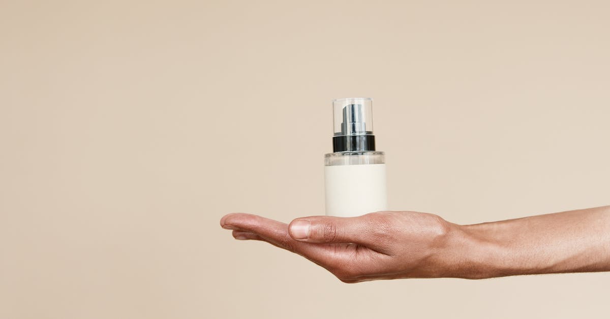 Can I carry hair oil and shampoo in my hand baggage? - Person Holding White and Silver Bottle