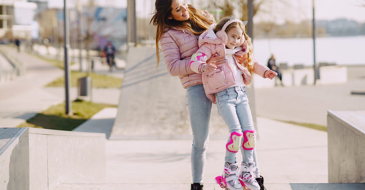 Can I carry roller blades in cabin baggage? - Full body smiling mother carrying little girl wearing protection pads while roller skating on concrete ramp during active leisure in sunny spring day