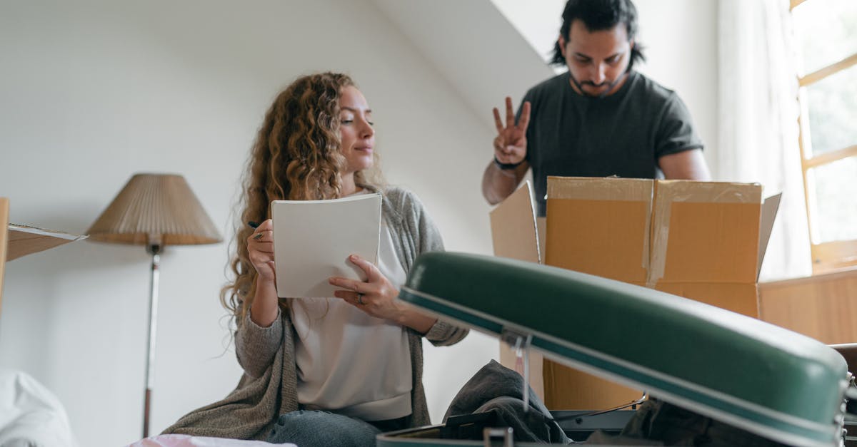 Can I check in a 35-kg suitcase? - Focused couple packing stuff before moving out