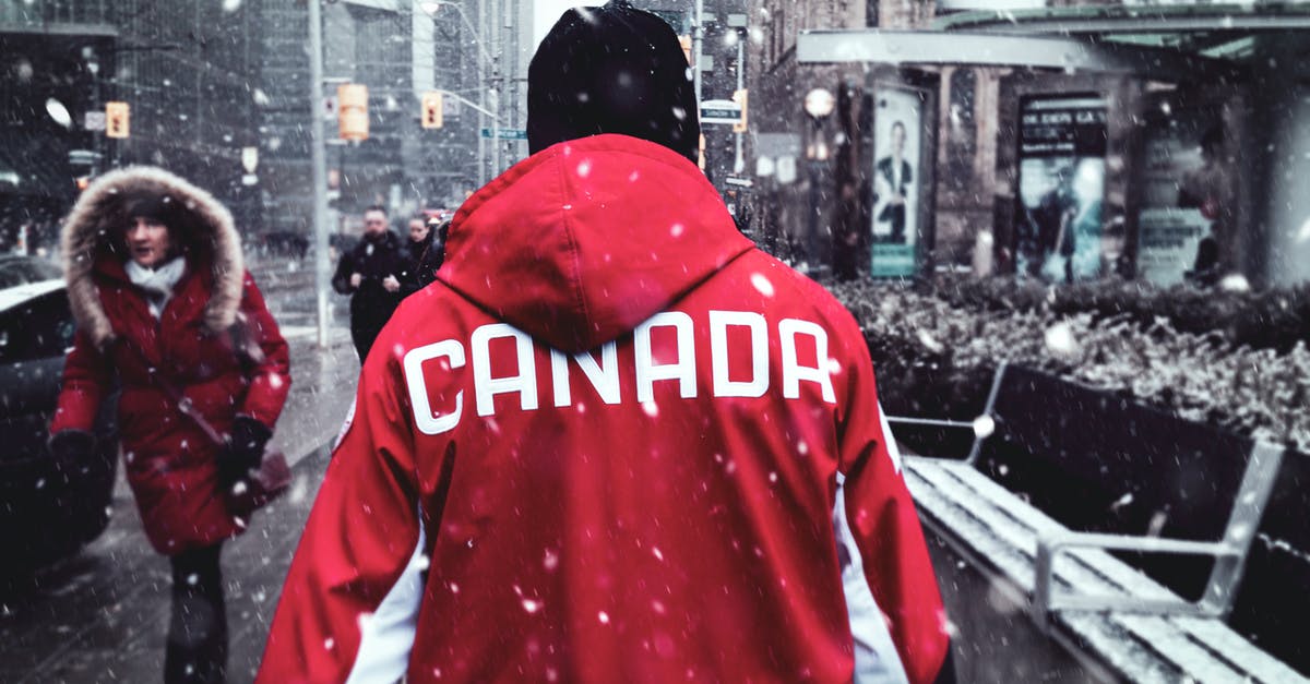 Can I come back to Canada with an expired passport? - Man in Red Hoodie Walking on Sidewalk