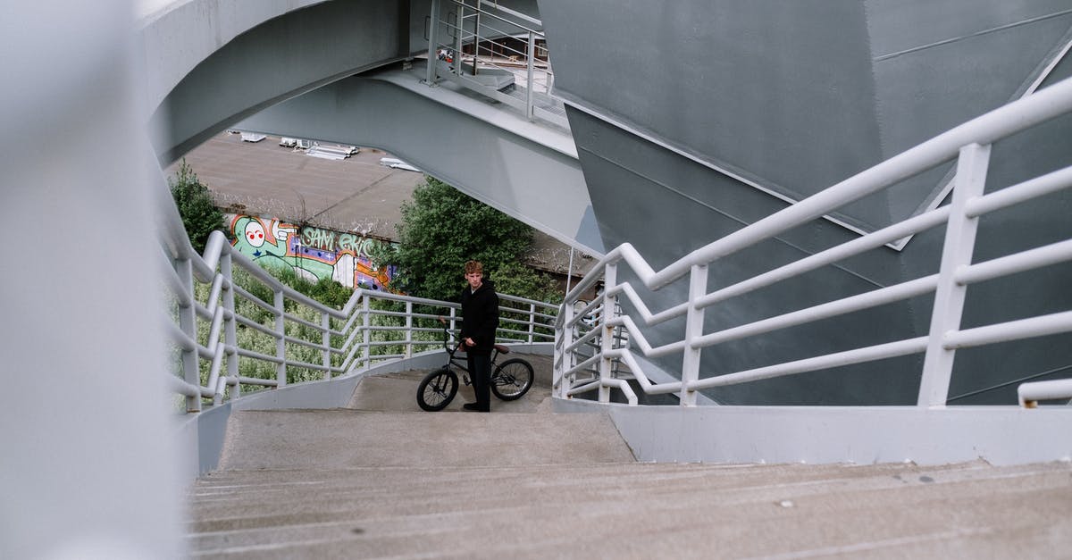 Can I cycle to Frankfurt Hahn airport from Koblenz? - Man in Red Jacket and Black Pants Walking on White Concrete Stairs