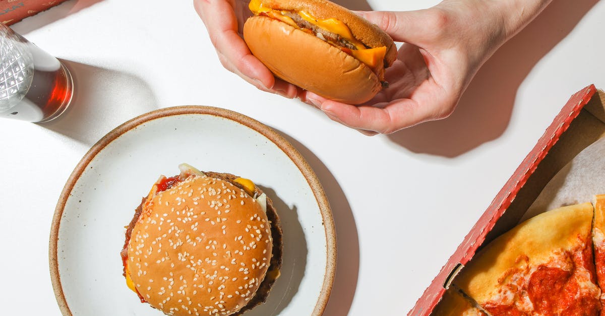 Can I eat a beef burger in India? - Person Holding A Cheeseburger