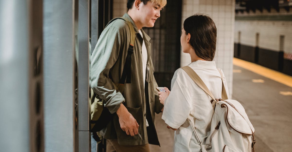 Can I enter an airport terminal, go to a departure gate, then go to a different terminal? - Stylish young ethnic couple entering underground station