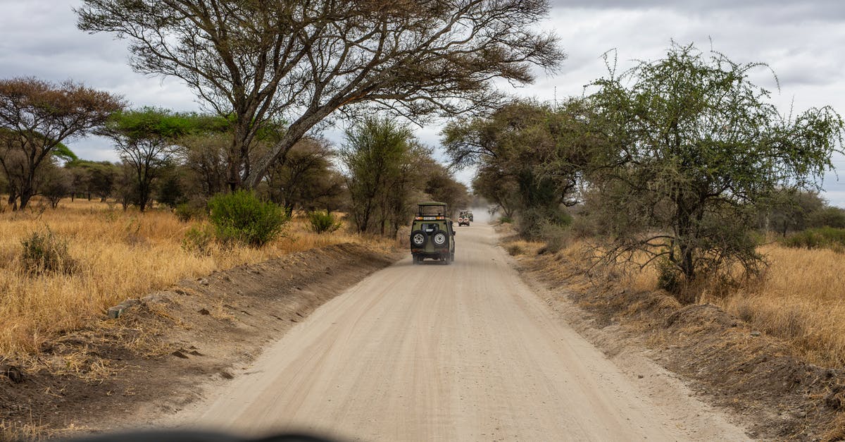 Can I enter Kenya and Tanzania multiple times on single-entry visas? - A Convoy of Safari Jeeps on Dirt Road