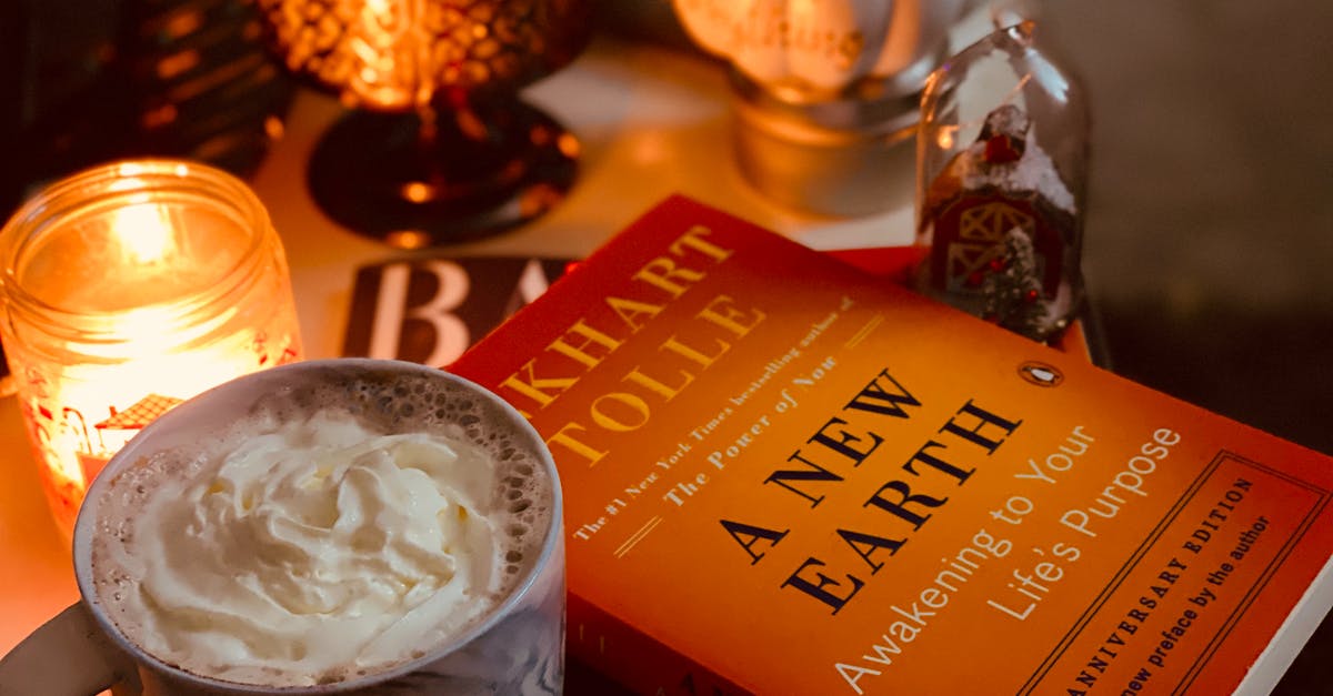 Can I enter the UK with short term study visa even though my course is over? - From above stack of modern literature books placed on bedside table near mug with glace coffee and burning tealight in candleholder