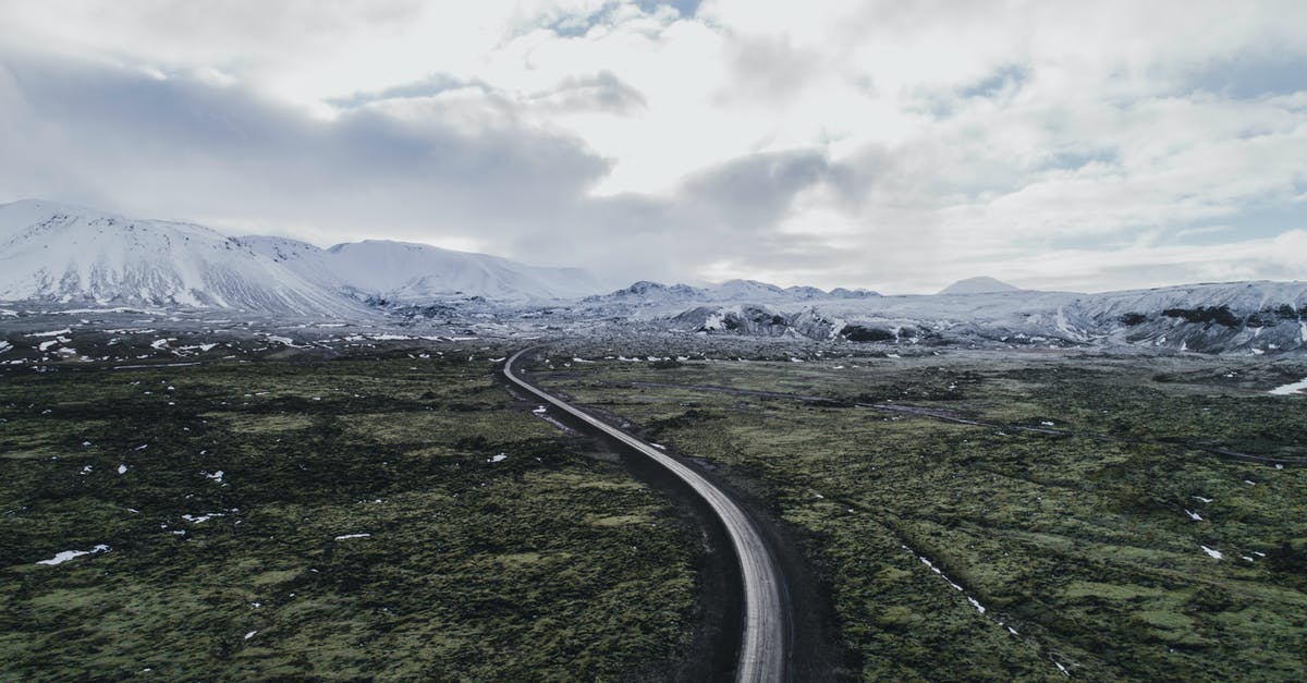 Can I expect "winter" scenery in Iceland in April? - Gray Asphalt Road Between Green Grass Field Under White Cloudy Sky