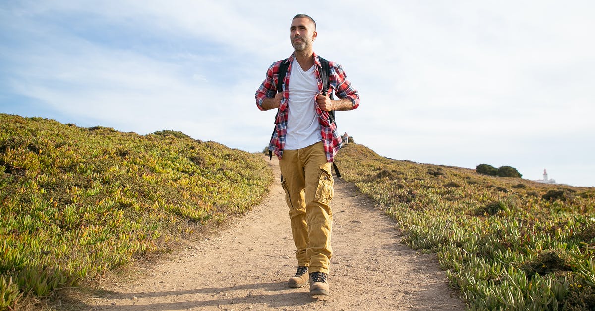 Can I extend my Chile tourist visa? - Man in Red and White Plaid Dress Shirt and Brown Pants Walking on Gray Asphalt Road