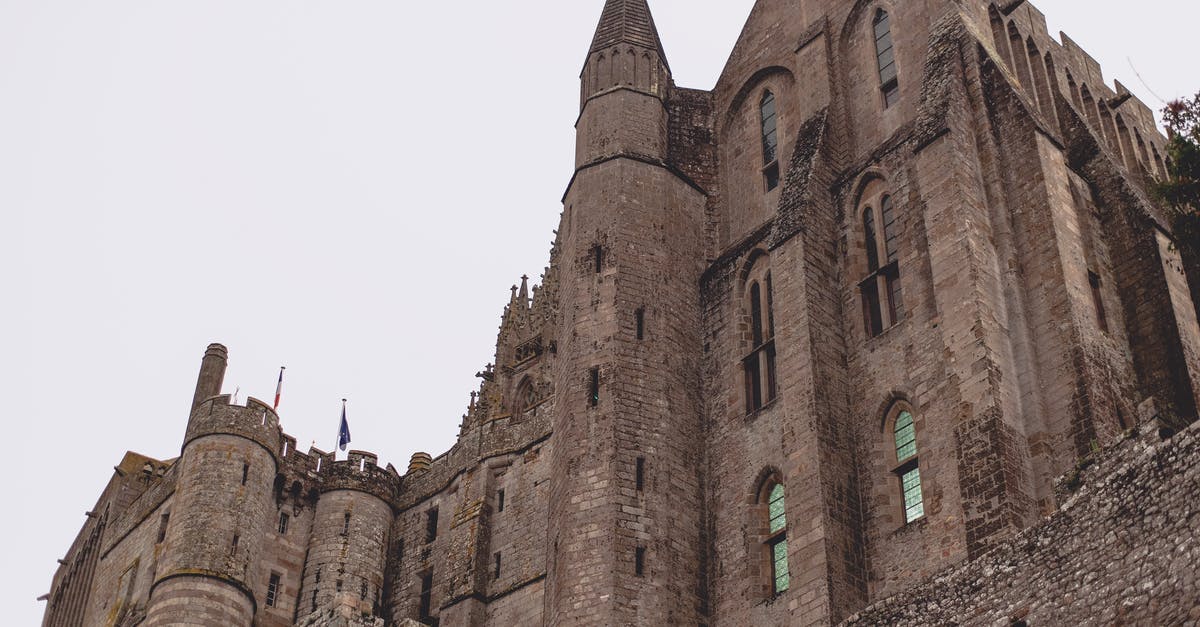 Can I extend my Schengen visa from France in Italy? - Brick Gothic abbey castle against gray sky