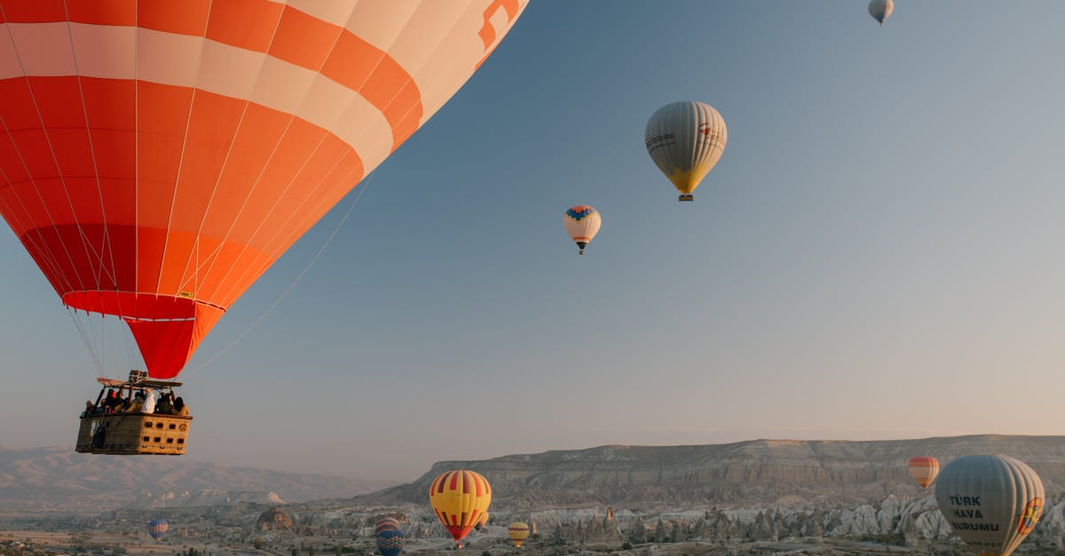 Can I fly via a third city on a second ticket? - Colorful air balloons flying over old eastern city