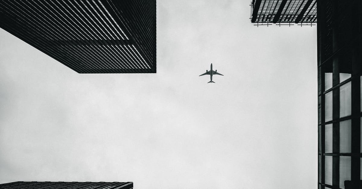 Can I fly via a third city on a second ticket? - Low Angle Photography of Airplane And Buildings