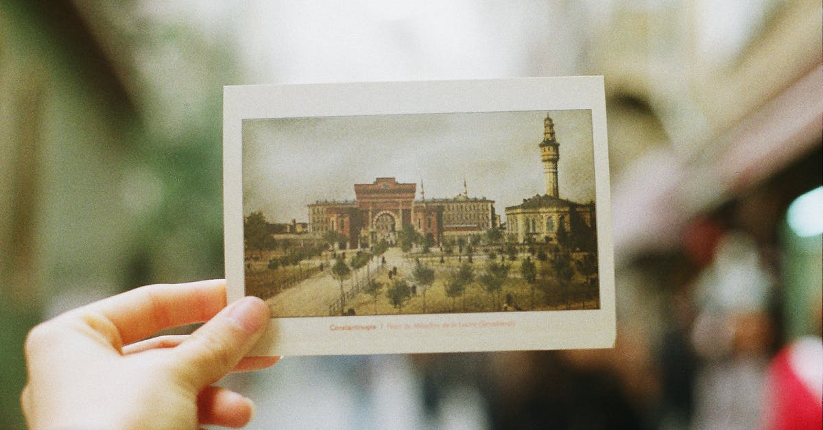 Can I get a Turkish transit visa at Istanbul airport? - Crop person showing postcard with photography of old city