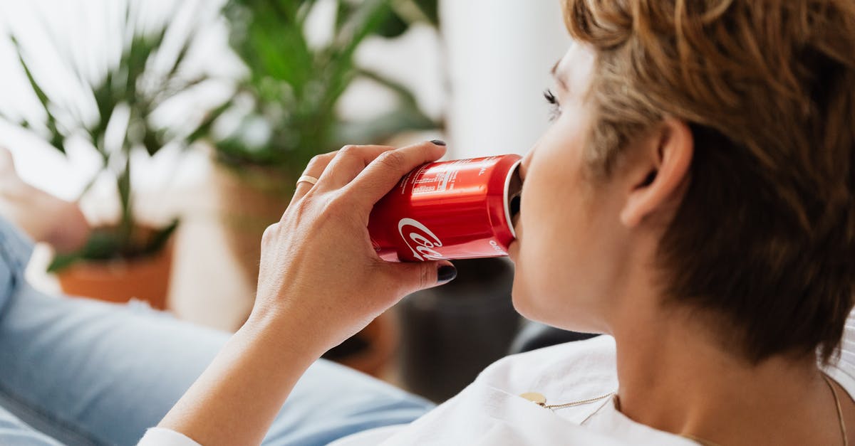 Can I get a UK Visa at short notice? - Crop unrecognizable thoughtful female enjoying coke while resting at home