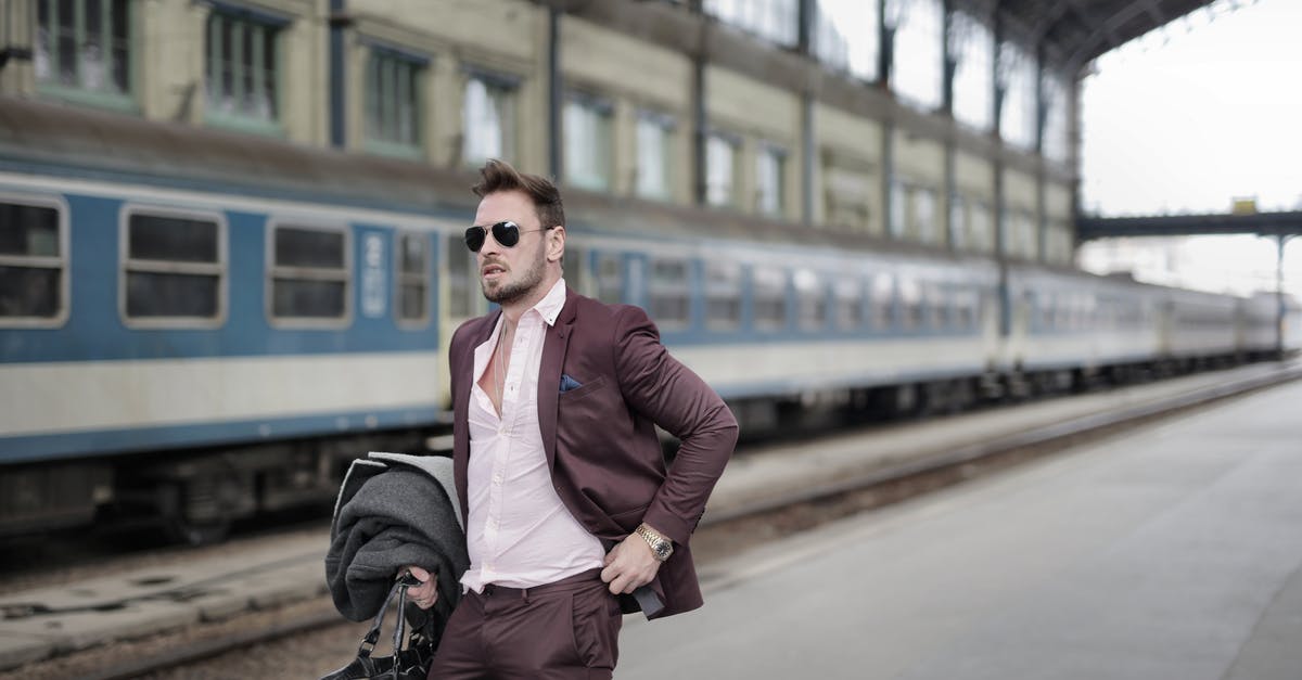 Can I get off the train or discontinue my journey before reaching the destination station? - Confident trendy male traveler in sunglasses standing on platform on railway station